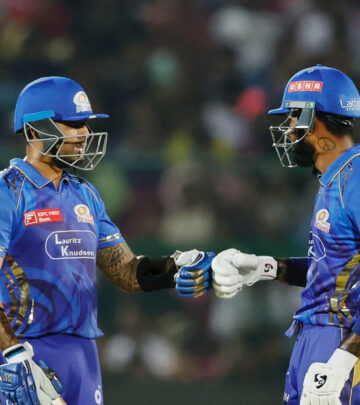 Players ignite team spirit, uniting force on cricket pitch amid roaring applause.